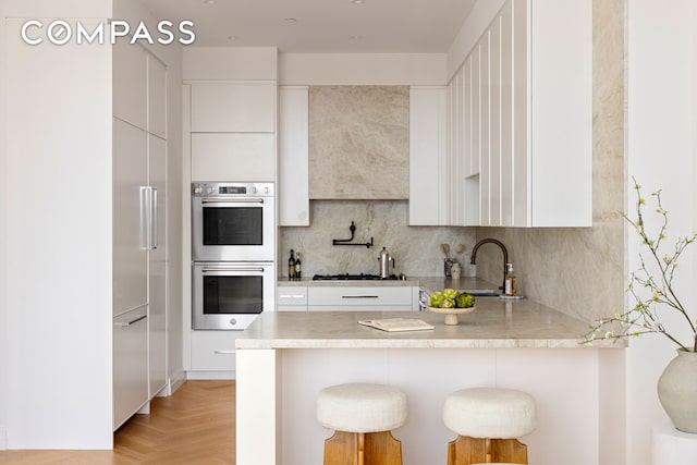 kitchen with white cabinetry, modern cabinets, and appliances with stainless steel finishes