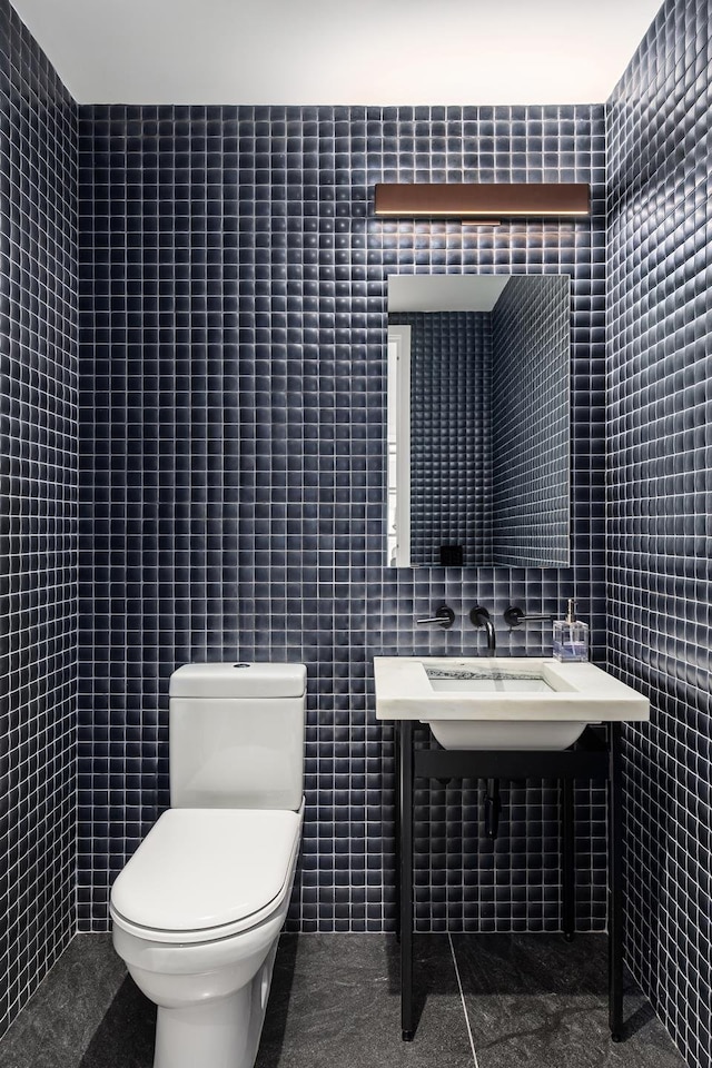 bathroom with tile walls, toilet, and tile patterned floors