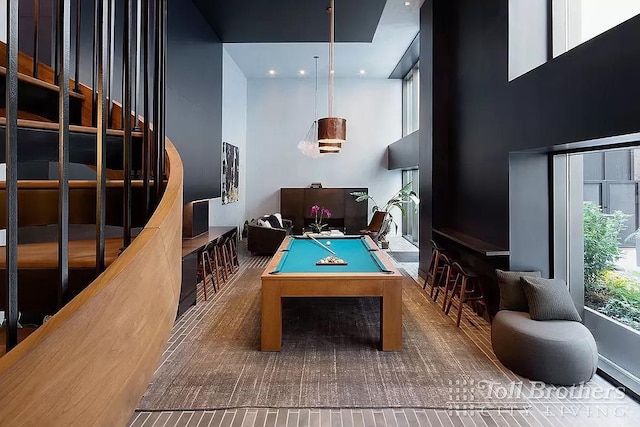 recreation room featuring a towering ceiling and pool table