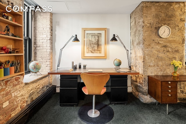 carpeted home office featuring brick wall and built in study area