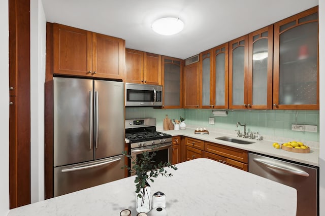 400 E 77th St Unit 3-A, New York City, NY 10075 - kitchen featuring stainless steel appliances, backsplash, glass insert cabinets, and brown cabinetry
