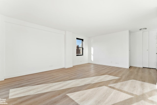 empty room featuring baseboards and wood finished floors