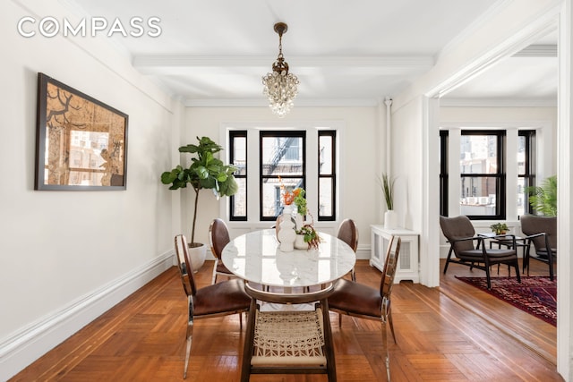 dining space featuring crown molding, a notable chandelier, and baseboards