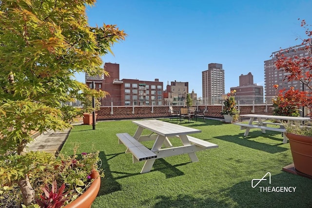 view of community with a lawn and a view of city