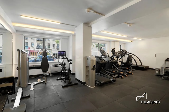 gym featuring a healthy amount of sunlight and baseboards
