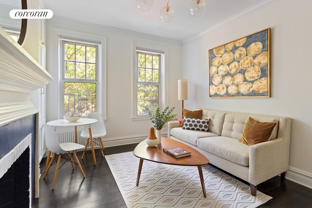 living room featuring baseboards, ornamental molding, and dark wood finished floors