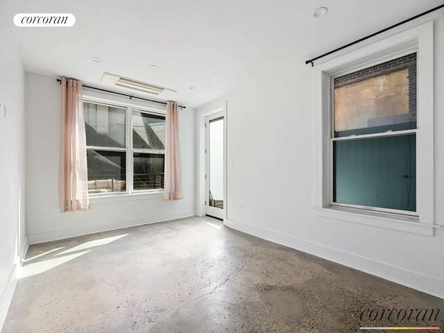 unfurnished room featuring visible vents, concrete floors, and baseboards