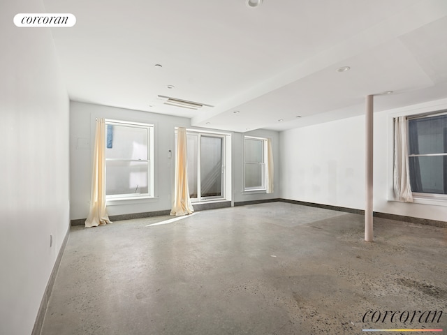 empty room with concrete flooring, visible vents, and baseboards