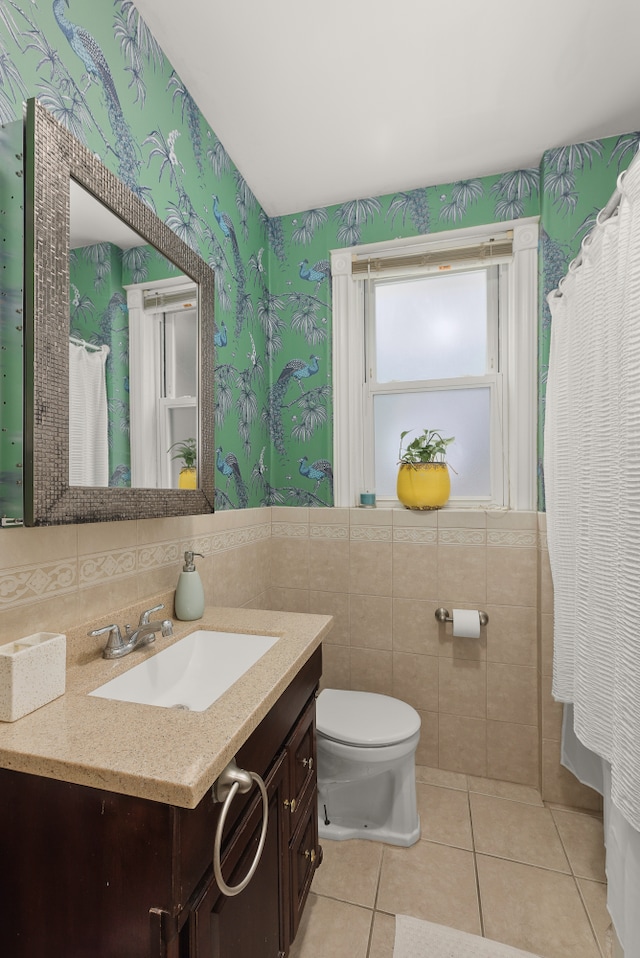 full bath featuring toilet, vanity, tile walls, tile patterned floors, and wallpapered walls