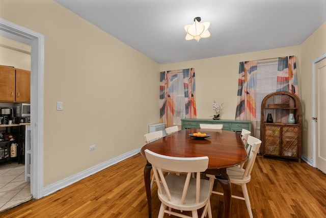 dining area with light wood-type flooring and baseboards