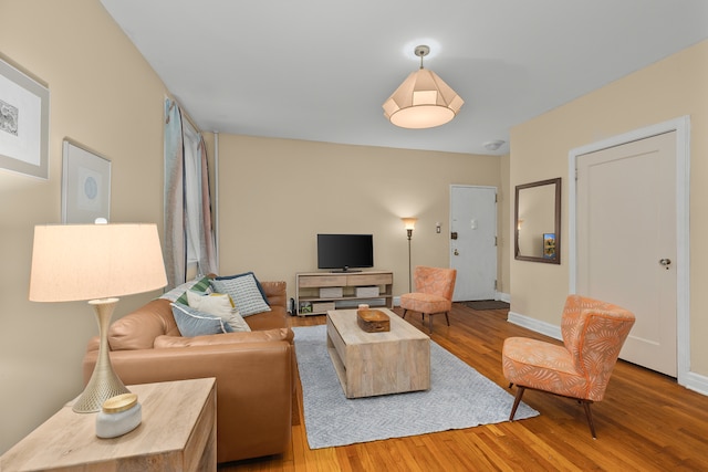 living area with baseboards and wood finished floors