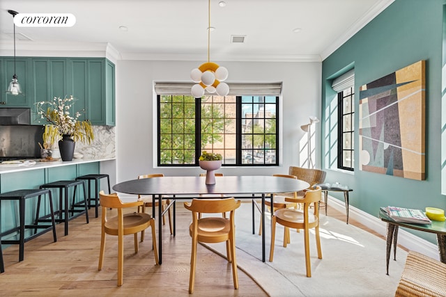 dining area with ornamental molding, baseboards, visible vents, and light wood finished floors