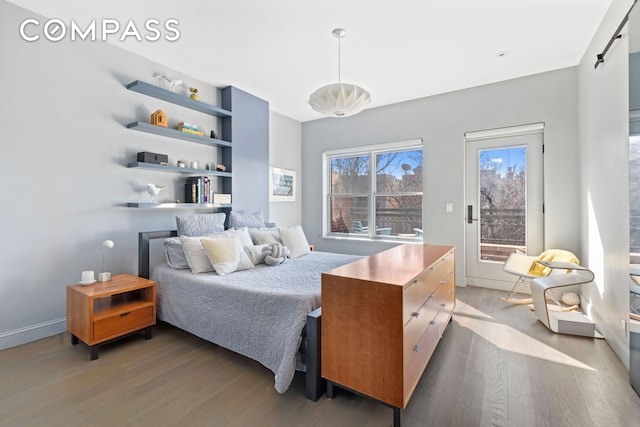 bedroom with access to outside, baseboards, and wood finished floors