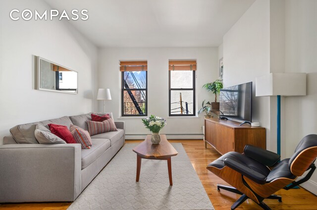 living room with a baseboard radiator and light wood-style floors