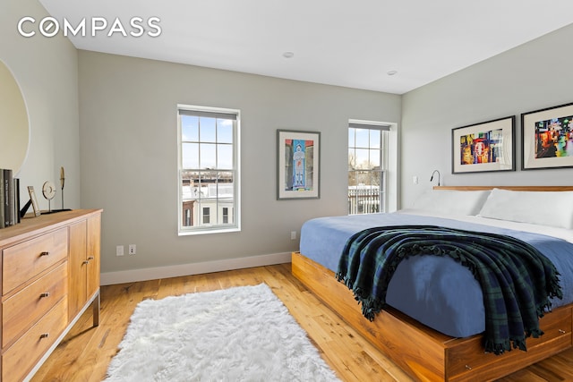 bedroom featuring baseboards and light wood finished floors