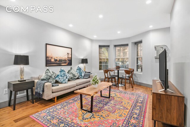 living room featuring recessed lighting, baseboards, and wood finished floors