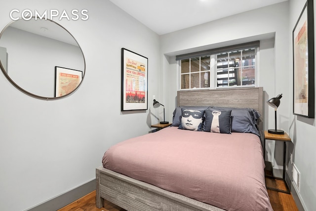 bedroom featuring baseboards and wood finished floors