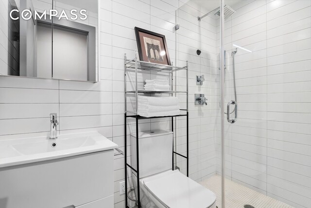 full bath featuring vanity, a shower stall, tile walls, toilet, and tasteful backsplash