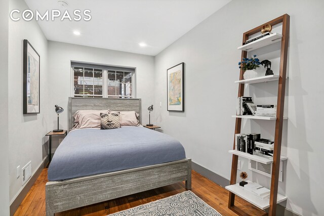 bedroom with recessed lighting, visible vents, baseboards, and wood finished floors