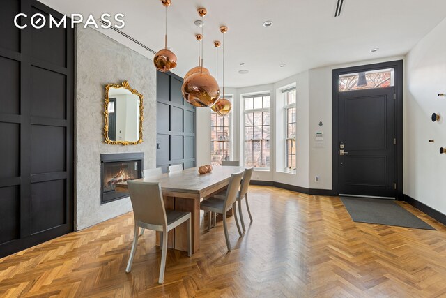 dining space featuring a high end fireplace, visible vents, baseboards, and recessed lighting