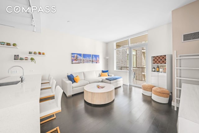 living area featuring wood-type flooring, visible vents, and track lighting