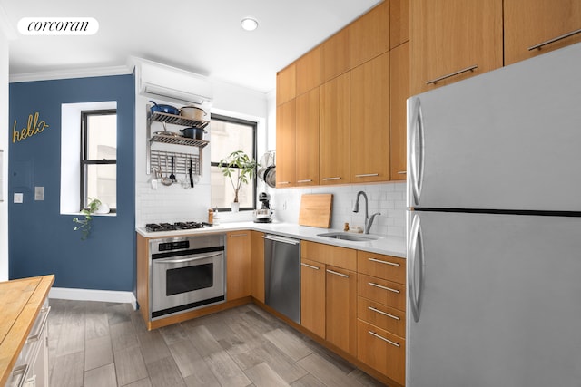 kitchen featuring visible vents, decorative backsplash, ornamental molding, stainless steel appliances, and a sink