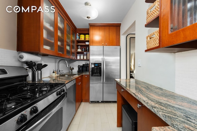 kitchen featuring a sink, open shelves, dark stone counters, and stainless steel appliances