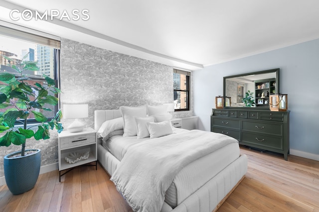 bedroom featuring baseboards, hardwood / wood-style floors, and ornamental molding