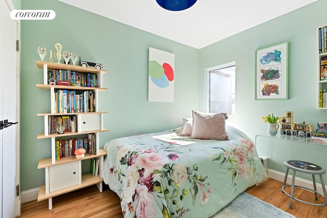 bedroom with baseboards and wood finished floors