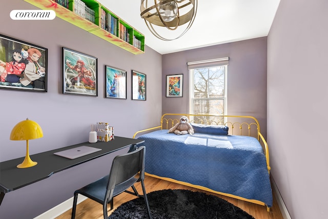 bedroom featuring visible vents, baseboards, and wood finished floors