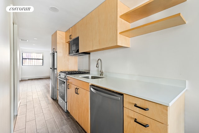 kitchen with appliances with stainless steel finishes, light countertops, light brown cabinets, open shelves, and a sink