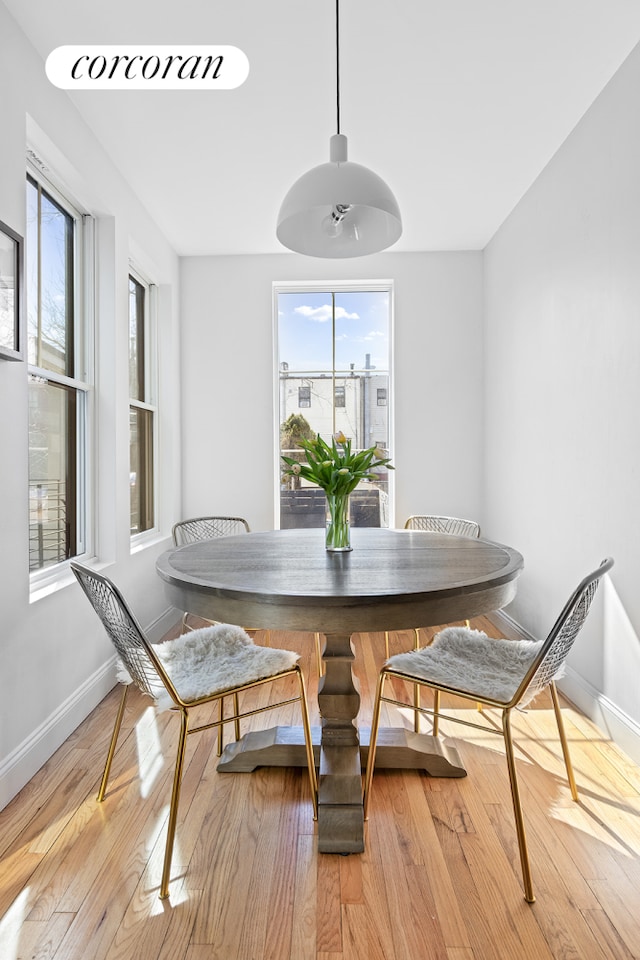 dining area with light wood-style floors and baseboards