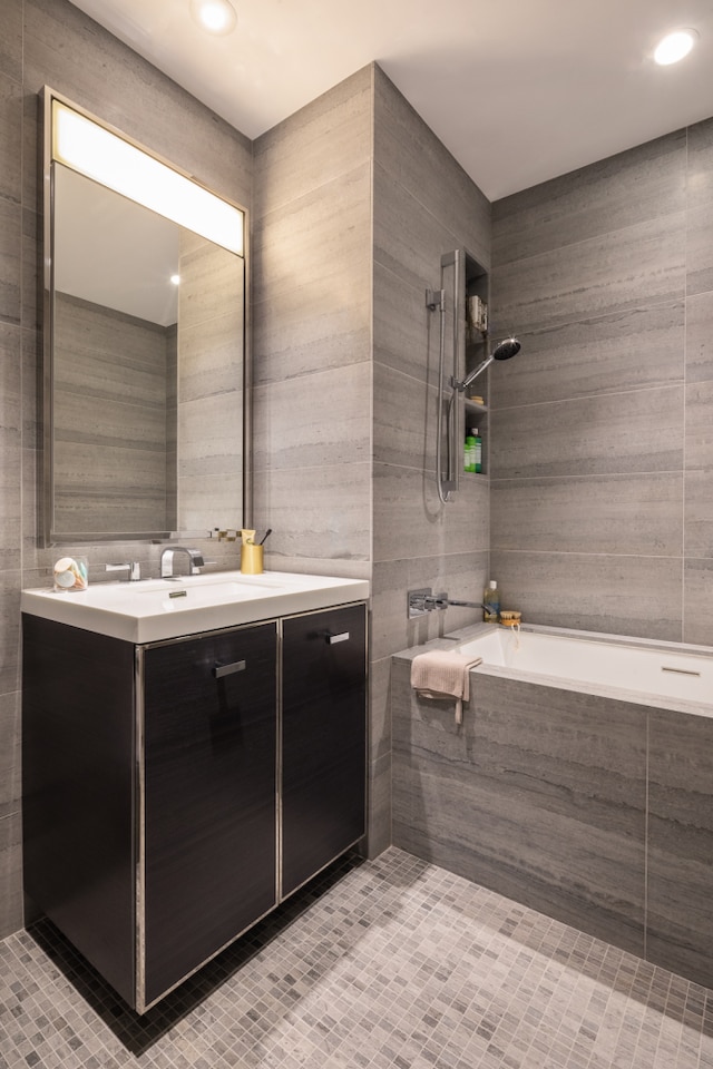 bathroom with tile walls, tub / shower combination, and vanity