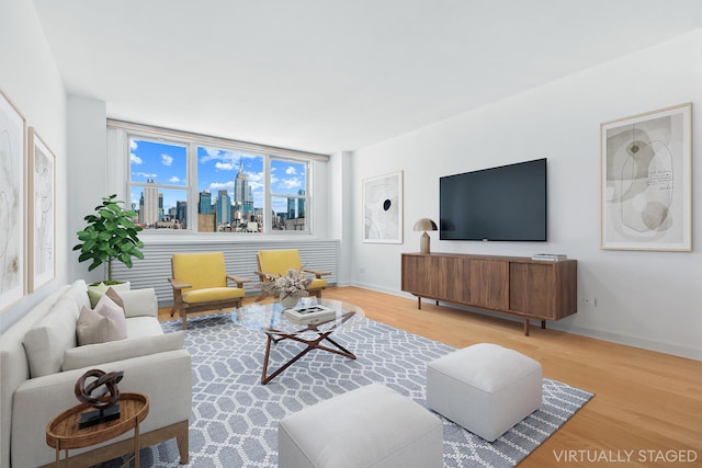 living area featuring baseboards and wood finished floors