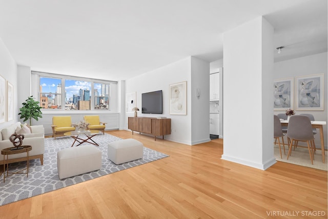 living area with light wood-type flooring and baseboards