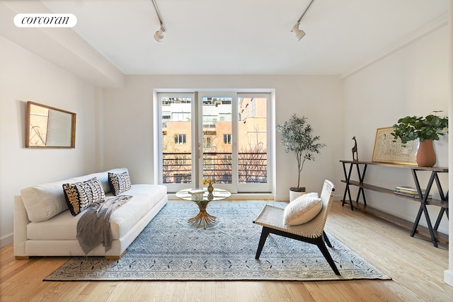 living area featuring rail lighting, visible vents, and wood finished floors