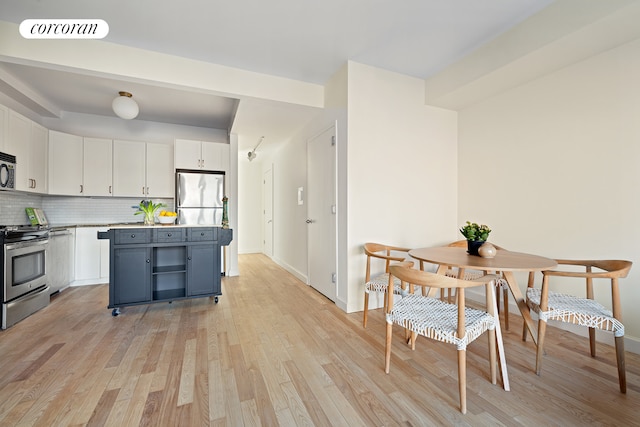 kitchen with tasteful backsplash, visible vents, light wood-style flooring, appliances with stainless steel finishes, and white cabinets