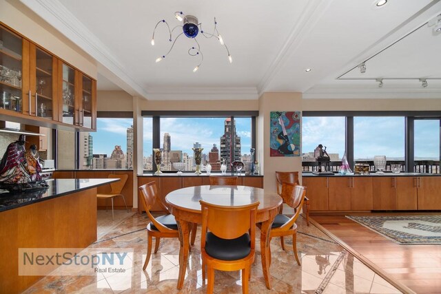 dining area with a healthy amount of sunlight, marble finish floor, a view of city, and crown molding