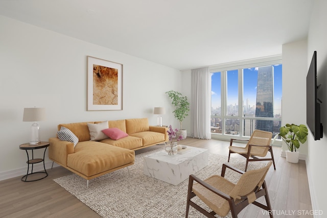 living area with floor to ceiling windows, light wood-style flooring, and baseboards