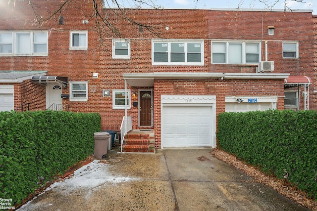 view of property with brick siding, driveway, and an attached garage