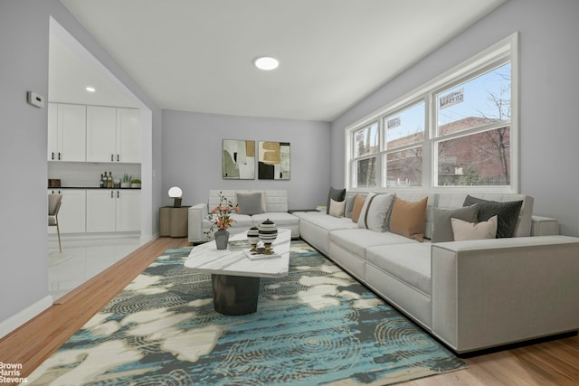 living room featuring baseboards, wood finished floors, and recessed lighting