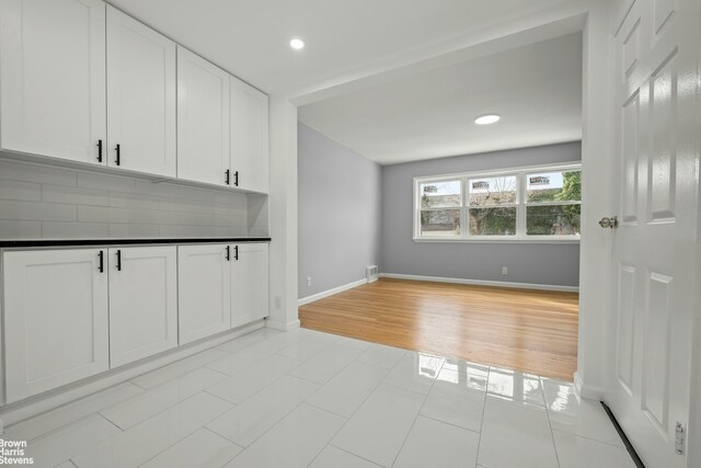 interior space with light tile patterned floors, baseboards, and recessed lighting