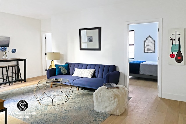 living area with baseboards and wood finished floors