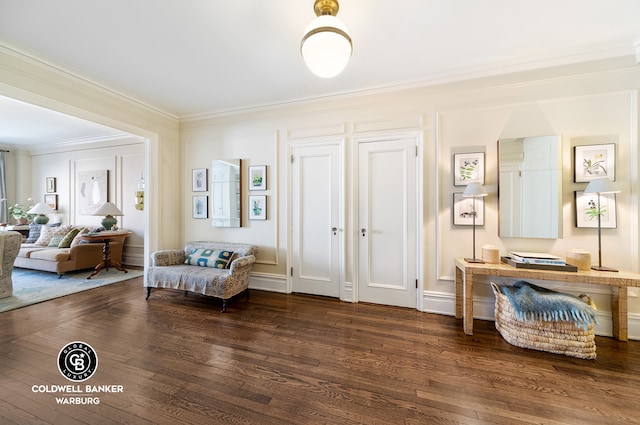 sitting room with dark wood-style floors and ornamental molding