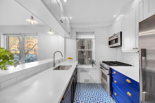 210 Congress St Unit 1D, New York City, NY 11201 - kitchen featuring stainless steel appliances, a sink, white cabinetry, light countertops, and blue cabinets