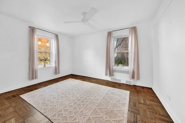 unfurnished room featuring radiator, ceiling fan, and baseboards