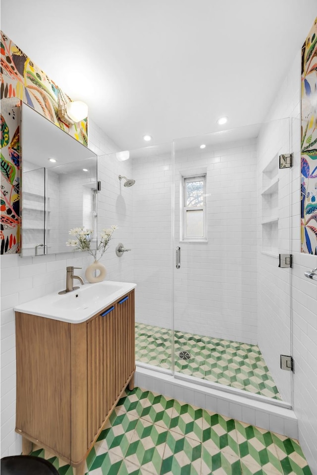 full bath featuring tile walls, a stall shower, tile patterned floors, and vanity