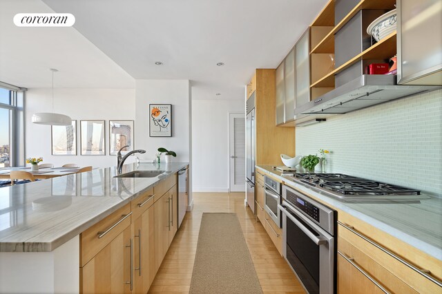 kitchen with light stone counters, a sink, visible vents, appliances with stainless steel finishes, and light brown cabinetry