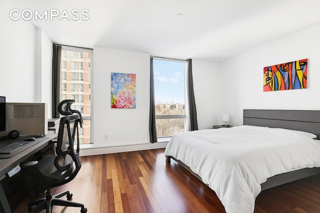 bedroom with multiple windows and wood finished floors