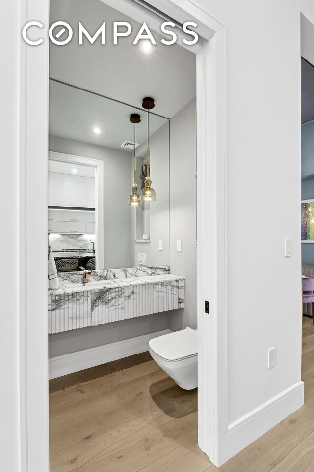ensuite bathroom with visible vents, connected bathroom, wood finished floors, and toilet